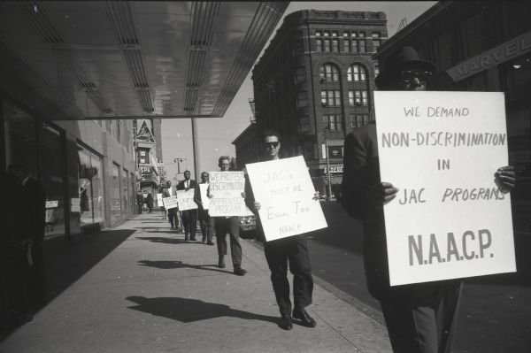 National Association for the Advancement of Colored People (NAACP) picketers outside the Schroeder Hotel where the Apprenticeship meeting was held. A Blatz Beer sign can be seen in the background.