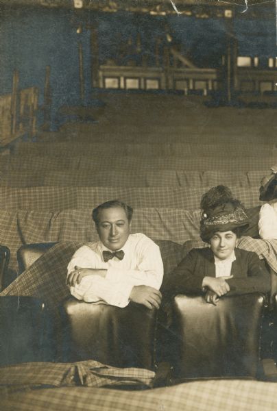Henry and Renee Harris are seated together in an almost-empty theater. This is half of a photograph that includes three other people in the side not visible.