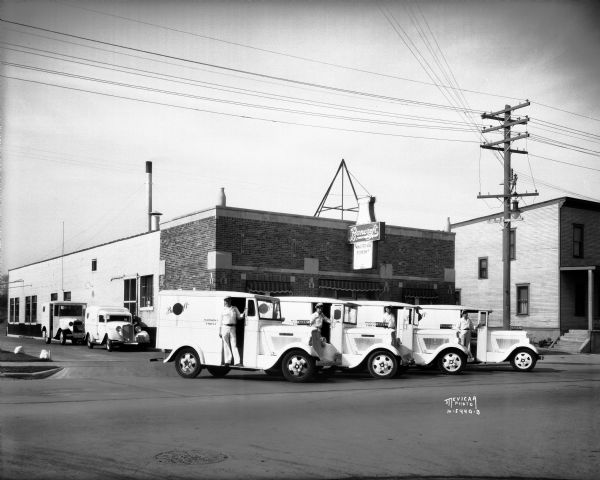 Four milk delivery trucks and drivers at Bancroft Dairy, 1010 South Park Street. The driver on the far left is Martin Kelly, and the third driver from the left is James E. McKiernan.
