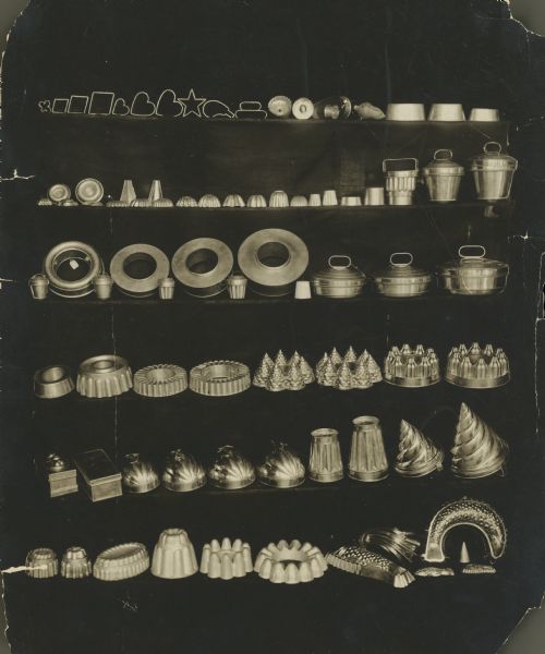 A display of metal kitchen utensils including cookie cutters, cake pans and molds.