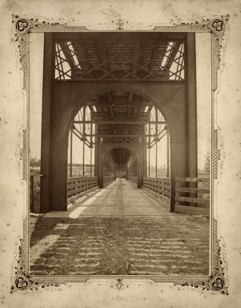 View of the lower level of the Chicago, Milwaukee, and St. Paul railroad bridge at the Wisconsin Dells that would have been used by pedestrians and horse-drawn vehicles. The railroad tracks are on the top level. This photograph was taken in when the Wisconsin Dells was still known as Kilbourn.