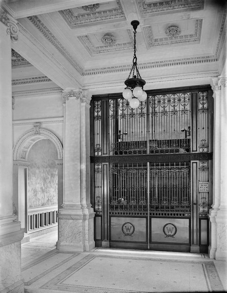 The elevator in the State Historical Society of Wisconsin photographed shortly after the completion of the building in 1900. The elevator is stopped on the third floor. Just the top of the head of the operator is visible.