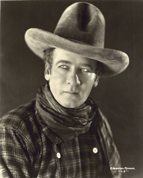 Thomas Santschi Publicity photograph of actor Thomas Santschi for the film "The Wagon Master." He is wearing a large cowboy hat, a scarf wrapped around his neck, and a checked shirt.