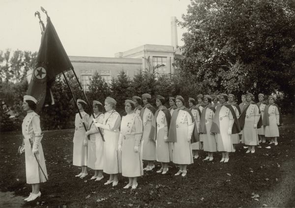 American Legion Auxiliary Drill Team The drill team is outdoors in formation with flags.