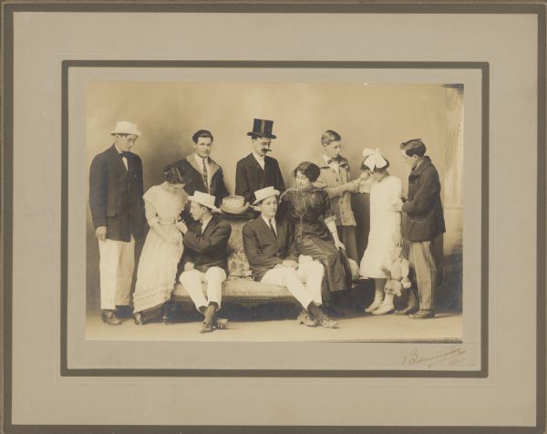 Group portrait of seven young men and three young women, in costume and seated or standing around a couch. Caption reads: "Augusta Masie Breed. Senior Class Play, Neillsville H.S. — 1912".