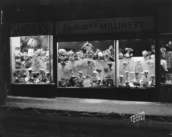Sandra's Hat Shop Sandra's Hat Shop, 101 State Street, with three show windows displaying hats, and a sign that reads: "Sandra's Exclusive Millinery."