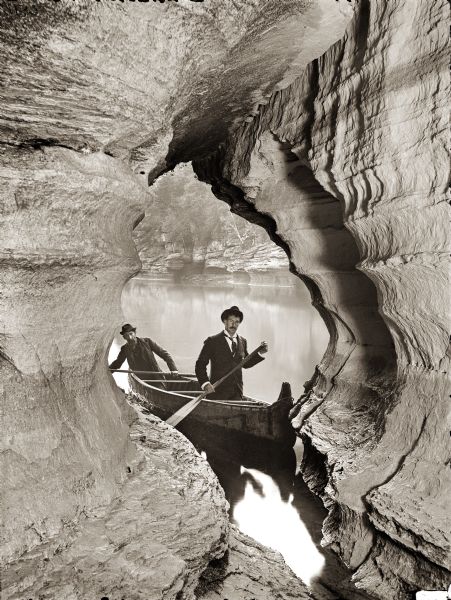 View out to the river from Boat Cave. At the entrance of the cave are two men in a canoe. H.H. Bennett's brother, John, is the paddler in the bow of the boat.
