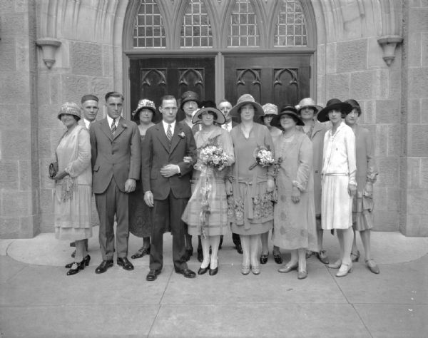 Group portrait of Mildred House and Lloyd Coleman wedding party and guests in front of the 1st Methodist Church, 203 Wisconsin Avenue.