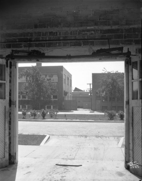 Schoelkopf Manufacturing Company, manufacturers of Air-Lec power door operators. The doors are in an open position, view from indoors looking out towards the street.