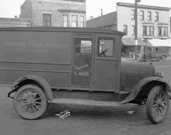 Damaged University Floral Company truck in the street across from Alban Ehrman Grocery Store, 716 University Avenue and Madison Bedding Company, 714 University Avenue.