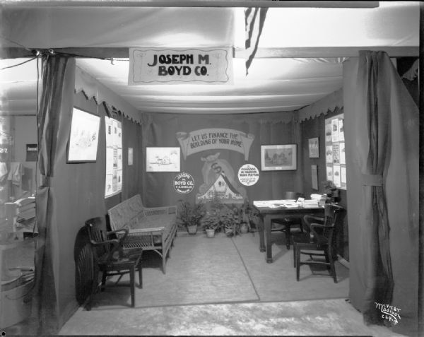 Joseph M. Boyd Co. booth at home show, set up as an office with a sign that reads: "Let us finance the building of your home."