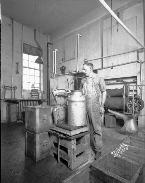 Man weighing a milk can on an old scale at Mt. Horeb Creamery.
