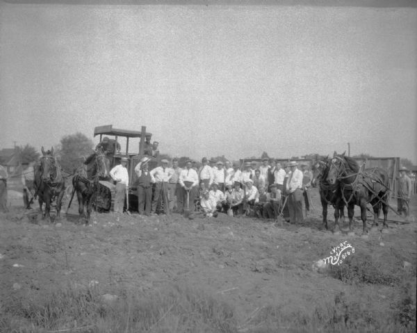 Group portrait of ESBMA (East Side Business Men's Association) men posing after clearing field for playground at Burr Jones Field, 1800 E. Washington Avenue. Includes work horses.