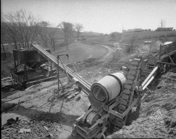 Elevated view of the stone crushing plant of the Wisconsin Foundry and Machine Company on Highway 27 near Soldiers Grove, showing a truck being filled with road gravel from the hopper.