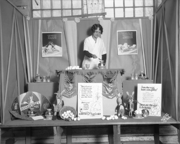 Mock Easter display window with woman demonstrating Hankscraft egg cooker.