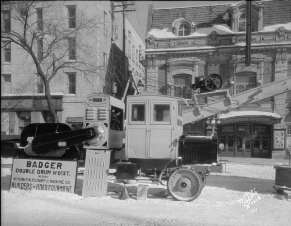 Wisconsin Foundry & Machine Company road equipment exhibit, showing Badger double drum hoist exhibited on Monona Avenue, with Woolworth's and Garrick Theatre in the background.