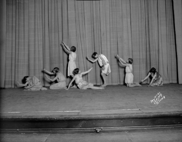 Indoor group portrait of Central High School girls' doing interpretive dance posing on a stage.