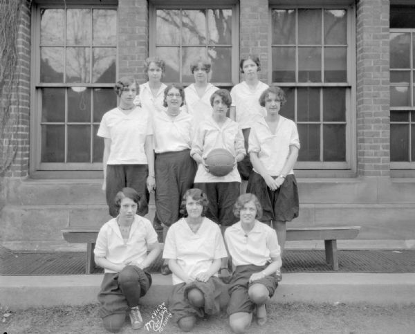 Outdoor group portrait of the Central High School 11B girls basketball team. They are dressed in bloomers.