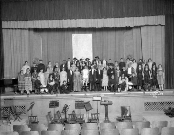 Indoor group portrait of the East High School Operetta cast of "The Fire-Prince," posing on a stage.