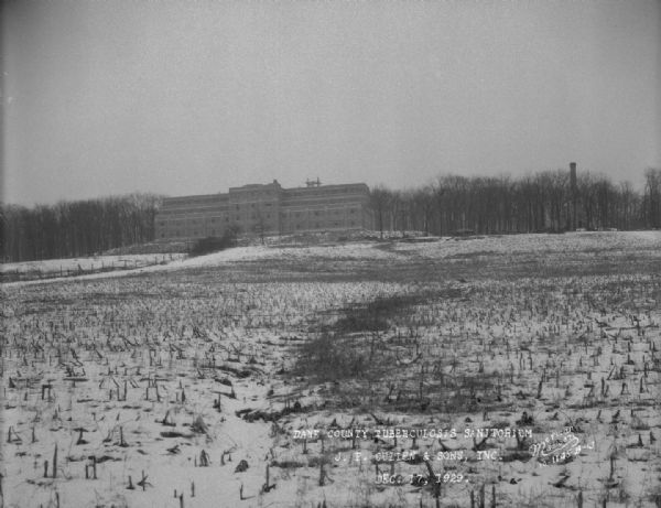 View up hill towards the Dane County Tuberculosis Sanitorium, with construction nearing completion, as seen from the front. Snow is on the ground. 1202 Northport Drive. J.P. Cullen, Contractor.