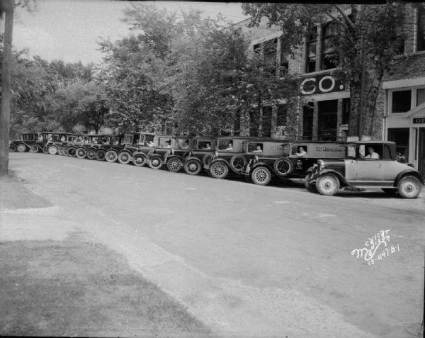 Fleet of 19 3-F Steam Laundry trucks and one automobile with drivers sitting at the steering wheels in front of the office and plant at 731 - 747 E. Dayton Street.