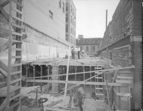 Addition to State Bank of Wisconsin under construction, with construction workers. 1 W. Main Street.