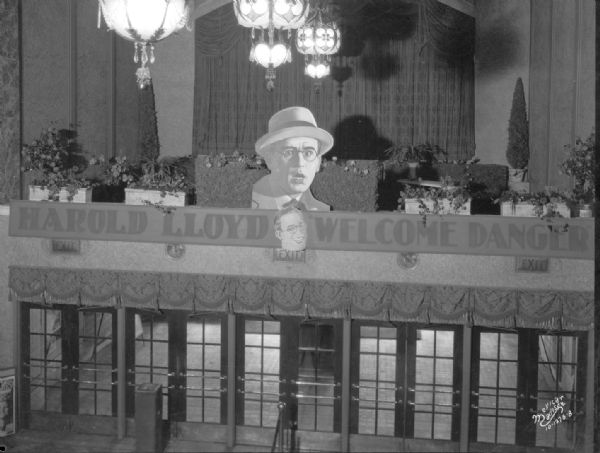 Capitol Theatre lobby garden from balcony showing Harold Lloyd advertising. "Harold Lloyd, Welcome Danger."