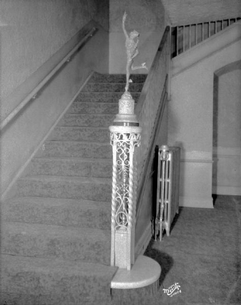Vertical interior view of Eastwood Theatre featuring staircase and newel post with statue of Mercury.
