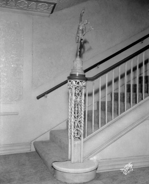 Vertical interior view of Eastwood Theatre, featuring staircase and close-up of newel post with statue of Mercury. 2090 Atwood Avenue.