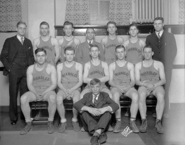 Group portrait of YMCA Triangles basketball team, and four coaches.