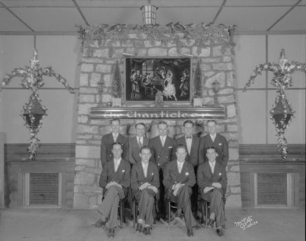 Chanticleer orchestra and manager posing in front of the fireplace.