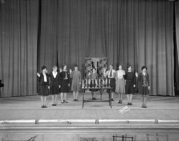 East High School, with nine students standing on stage being inducted as officers of the Student Club.