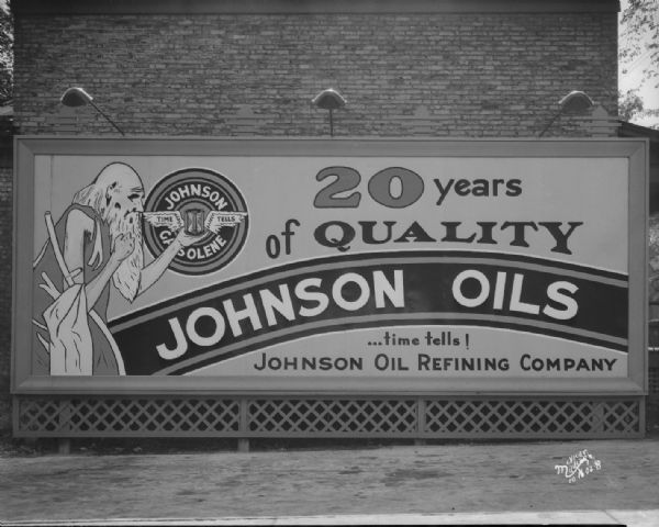 Johnson Oil Refining Company billboard. "20 years of quality ... time tells!" Featuring Father Time holding an hourglass in the center of the logo for "Johnson Gasolene, Time Tells."