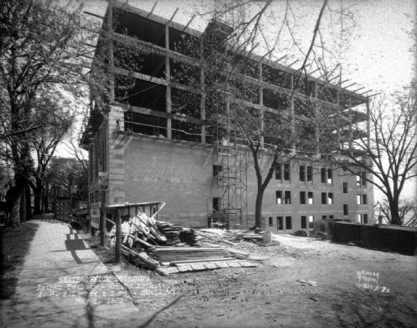 State Office Building, 1 W. Wilson Street, under construction. This is a side view, with two posters advertising: "10 Nights in a Barroom" at the Orpheum Theater.