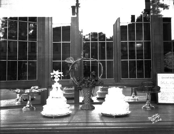 Display of wedding cakes in window of bakery of Felix Odehnal, 715 University Avenue.