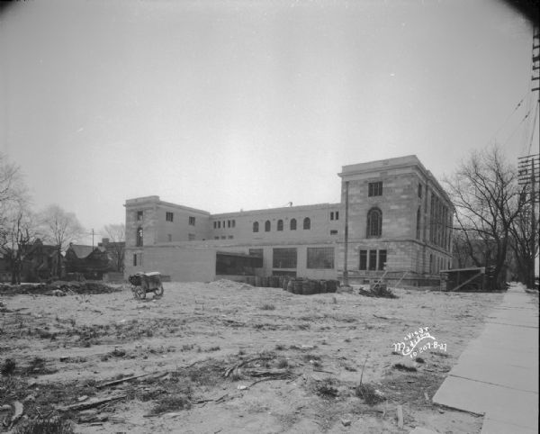 Looking south at rear of the building nearly complete, with barrels and lamppost.
