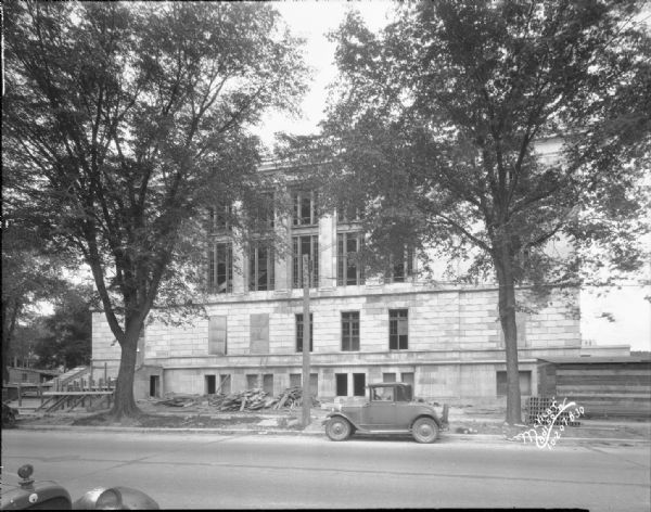 Wilson Street side of post office and courthouse nearly completed. There is an automobile parked along the curb in front.