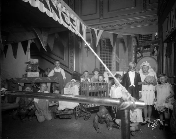 Children dressed as circus performers at the Orpheum Theatre, inside the lobby which is advertising "Swing High."