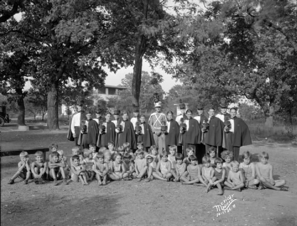 Outdoor group portrait of Floyd's Cadets (singers), a vaudeville act, and children at Kiddie Camp, 3910 Mineral Point Rd.