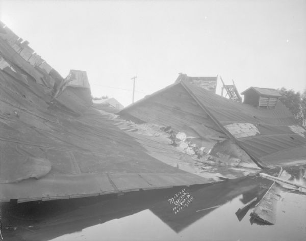 View across water towards the roof of a collapsed ice house.