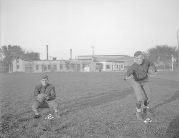 Two Central High School football players in uniform posing on the field.