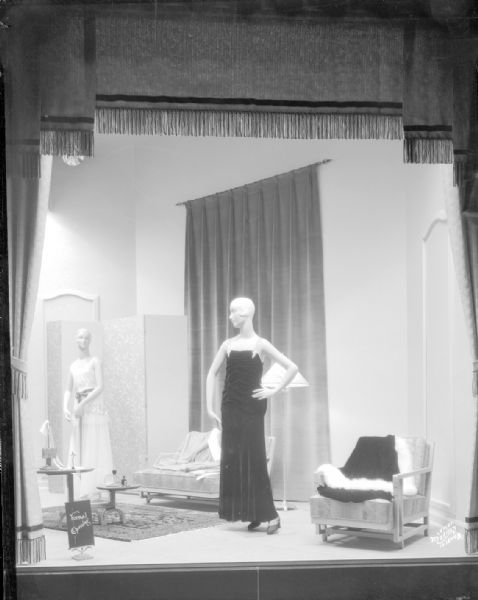Manchester corner display window featuring two women mannequins dresses in formal gowns.