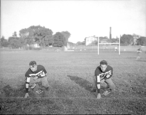 Portrait of two Wisconsin High School football players in a three point stance.