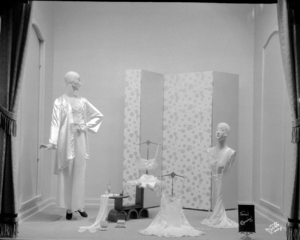 Manchester display window featuring one woman mannequin, and one woman bust mannequin, dressed in lingerie.