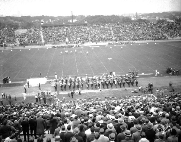 Elevated view of the stadium, with the marching band at Camp Randall at the University of Wisconsin-Carleton football game. The Madison skyline is in the background.
