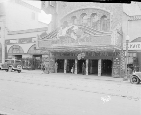 View across street towards the Capitol Theatre marquee featuring Bert Wheeler and Robert Woolsey in "Half Shot at Sunrise." Also shows Lurose women's clothing store, 205 State Street.