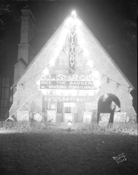 Chi Phi House, 200 Langdon Street, with the facade decorated as a theater with a marquee for homecoming. "See the Badgers in 'Smashing Pennsylvania.'" 1st prize homecoming decoration.
