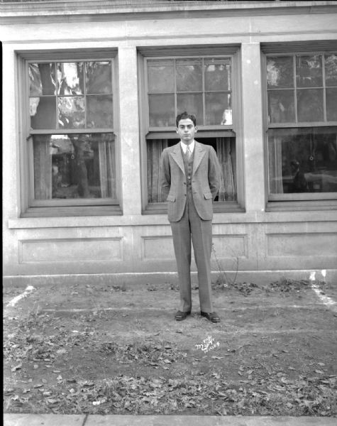 Portrait of Pi Lambda Phi fraternity brother standing outdoors in front of a building.