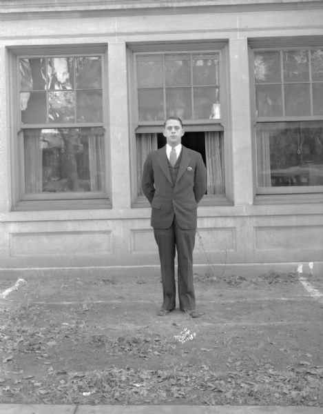 Outdoor portrait of Pi Lambda Phi fraternity brother standing in front of a building.