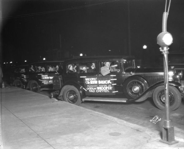 Parade of new Buicks advertising the midnight preview of the movie "Whoopee" starring Eddie Cantor playing at the RKO Capitol Theatre.